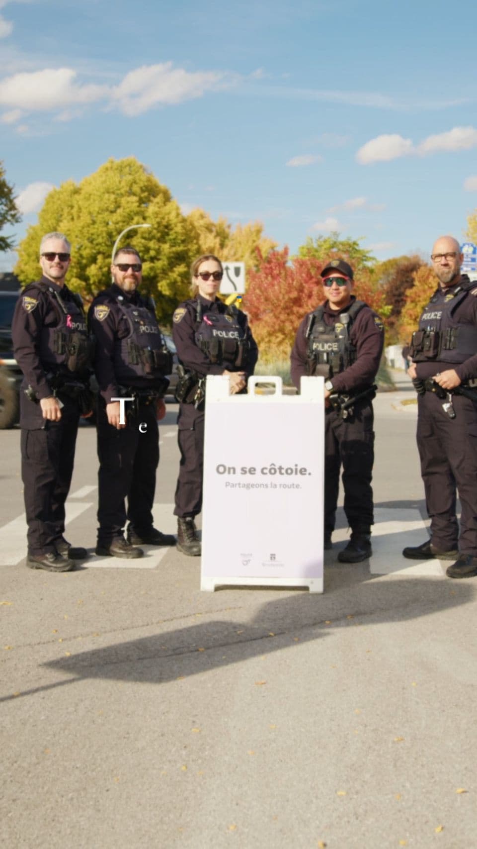 Policiers de Terrebonne autour d’une affiche « On se côtoie. Partageons la route. »